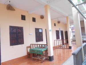 a room with wooden doors and a table and chairs at Sythane Guesthouse in Nongkhiaw