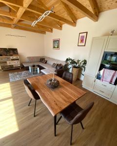 sala de estar con mesa de madera y sillas en Prosluněný dům s výhledem na Pálavu en Brod nad Dyjí
