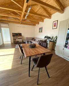 sala de estar con mesa de madera y sillas en Prosluněný dům s výhledem na Pálavu en Brod nad Dyjí