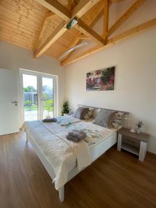 una camera con un grande letto e un soffitto in legno di Prosluněný dům s výhledem na Pálavu a Brod nad Dyjí