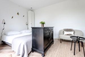 1 dormitorio con vestidor negro, cama y silla en #1Leafy Place, en Bentveld