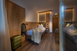 ein Hotelzimmer mit einem Bett und einem Spiegel in der Unterkunft Almhotel Lenz in Olang