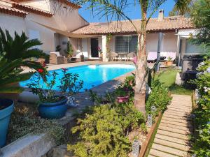 a swimming pool in the yard of a house at LA PASSIFLORE in La Londe-les-Maures