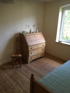 a bedroom with a wooden dresser and a window at Harmony 