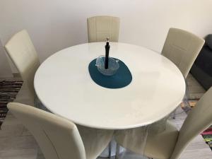 - une table à manger blanche avec des chaises blanches dans l'établissement Apartment Kozarica 4950b, à Kozarica
