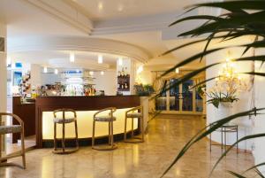 a restaurant with a bar with stools at Hotel Panoramic in Caorle