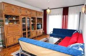 a living room with a blue couch and a table at Apartment Drvenik Gornja vala 4890a in Drvenik
