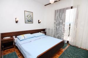 a bedroom with a large bed and a window at Apartment Drvenik Gornja vala 4890a in Drvenik