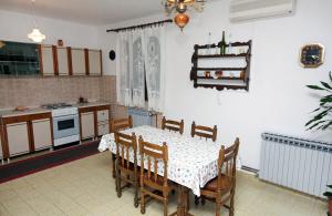 a kitchen with a dining room table and a table and chairs at Apartment Drvenik Gornja vala 4890a in Drvenik