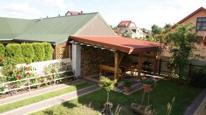 a house with awning and a bench in a yard at Noclegi Pod Różą in Krasnobród