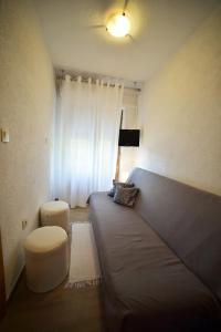 un piccolo soggiorno con divano e sedia di Apartment Mundanije 5072b a Rab