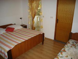 a bedroom with a bed and a window and a door at Apartment Kampor 5014b in Kampor