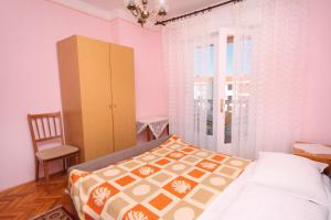 una camera con letto, sedia e armadio di Apartment Palit 5061a a Rab