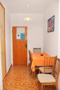 una sala da pranzo con tavolo, sedie e porta di Apartment Palit 5061a a Rab