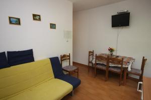 un soggiorno con divano e tavolo da pranzo di Apartment Zivogosce - Porat 6700a a Igrane