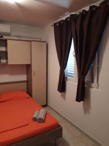 a bedroom with a red bed and a window at Apartment Blaca 4899e in Maranovići +22 photos