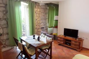 una sala da pranzo con un tavolo e una televisione di Apartment Gradac 6661a a Gradac (Grado)