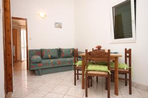 uma sala de estar com uma mesa e um sofá em Apartment Zaostrog 6659a em Zaostrog