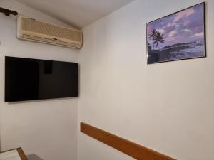 telewizor z płaskim ekranem na ścianie obok wentylatora w obiekcie Apartment Starigrad 6621a w mieście Starigrad-Paklenica