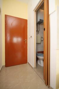a bathroom with a toilet and a brown door at Apartment Starigrad 6587b in Starigrad-Paklenica