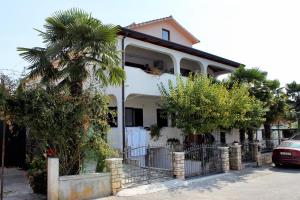 una casa bianca con una palma di fronte di Studio Novigrad 2536a a Novigrad Istria
