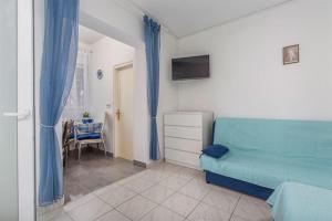 a living room with a blue couch and a table at Studio Novigrad 2536a in Novigrad Istria