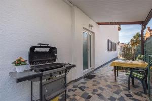 een barbecue op een patio met een tafel bij Studio Novigrad 2536a in Novigrad Istria