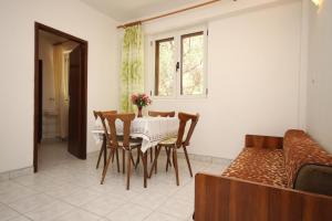 ein Esszimmer mit einem Tisch, Stühlen und einem Sofa in der Unterkunft Apartment Tucepi 6857a in Tučepi