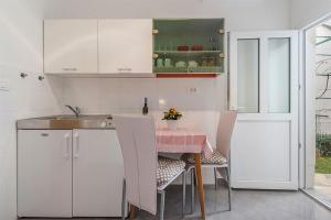 a kitchen with a table with chairs and a sink at Studio Novigrad 2536b in Novigrad Istria