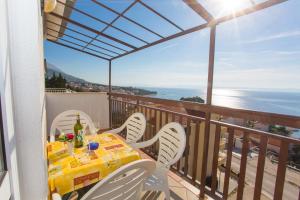 einen Tisch und Stühle auf einem Balkon mit Meerblick in der Unterkunft Apartment Baska Voda 6761d in Baška Voda