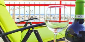 シャッカにあるThe most secluded terrace at the portの緑の椅子に座ってワインを楽しむ
