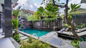 una piscina nel mezzo di un giardino di Ayu Sari Guesthouse by Mahaputra ad Ubud