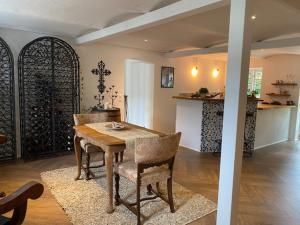 a dining room with a wooden table and chairs at Guldforhoved B&B 