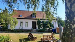 a white house with chairs in front of it at Ferienwohnung Landidylle in Wörpen