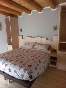 una camera con letto in una stanza con soffitti in legno di Agritur Manoncin a Daone