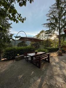 un tavolo da picnic con ombrellone in un parco di Casa Lastri a Poppi