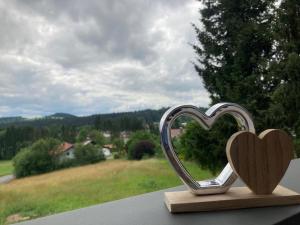 une paire de cœurs assise au-dessus d'un grand livre dans l'établissement Chalets zum Latschen, à Mauth