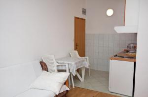 a kitchen with a table and chairs in a room at Studio Drvenik Gornja vala 4890e in Drvenik