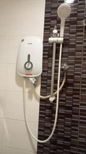 a bathroom with a shower with a hair dryer at Dream House Hotel in Skudai