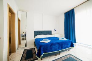 a bedroom with a blue bed and a mirror at Studio Selce 5206d in Selce