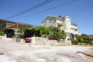 a house with a stone retaining wall in front of it at Studio Banjol 5071a in Rab