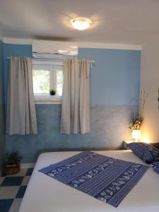 a bedroom with a bed and a window at Studio Banjol 5071a in Rab