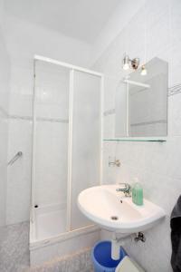 a white bathroom with a sink and a shower at Studio Banjol 5071a in Rab
