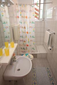 baño con lavabo y cortina de ducha en Studio Tisno 5091c en Tisno
