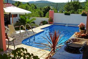 a swimming pool with a table and chairs and an umbrella at Studio Maslinica 5180a in Maslinica