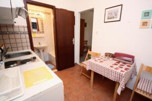 a kitchen with a table and a small kitchen with a sink at Studio Maslinica 5180a in Maslinica +14 photos