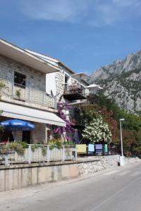 un edificio con fiori sul lato di una strada di Studio Gradac 6661a a Gradac (Grado)