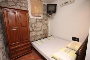 a small bedroom with a bed and a wooden cabinet at Studio Gradac 6661a in Gradac