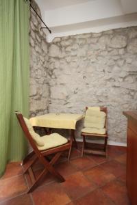 a table and chairs in a room with a stone wall at Studio Gradac 6661a in Gradac