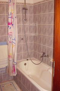 La salle de bains est pourvue d'une baignoire et d'un rideau de douche. dans l'établissement Studio Maslinica 5180c, à Grohote